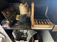 Shelf showing multiple items including cordless cutter, Guidemate jig, drill guide, bucket, chisel set case