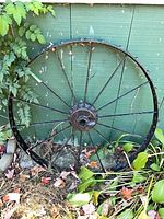 Full view of wagon wheel leaning against shed
