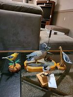 Group shot of all four carved wood birds on bases