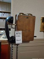 Front view of wood wall telephone showing handset and bells