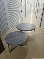 Both round tables side by side in hallway showing overall design and size relation