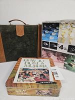 Front view showing murder game tin, backgammon case and glass games box