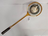 Full view of racquet sculpture displaying ceramic head in strings