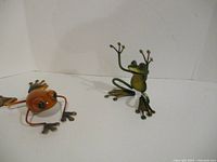 Both metal frog figurines side by side