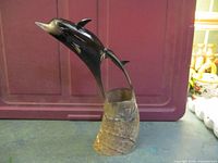 Front view showing full dolphin sculpture on horn base