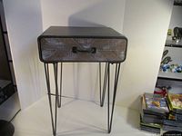 Front view of metal side table with drawer