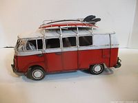 Left side view of red and white metal VW-style van model