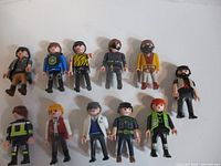 Group shot of eleven Playmobil figures arranged in two rows showing front detail of each character