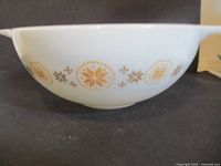 Side view of white Pyrex bowl showing gold snowflake pattern and side spout/handle