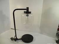 Full view of black metal lamp with glass shade