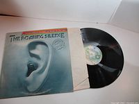 Front jacket with ear artwork plus partially pulled record and inner sleeve