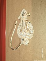 Side view of ornate cast iron hook showing shape and paint