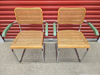 Front view of both Cesca chairs showing cane seats/backs, chrome frames, green armrests