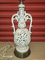 Lamp base close-up showing reticulated porcelain body, cord and plug