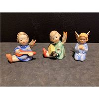 Front view of three porcelain Goebel angel figurines