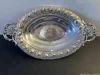 Top view of oval 800 silver dish showing handles, floral border and central monogram