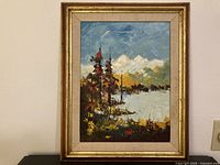 Framed oil painting showing mountain lake scene