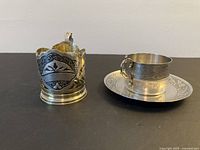 Front view of glass holder and cup with saucer