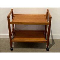 Front view of teak two-tier trolley cart showing shelves, frame and casters