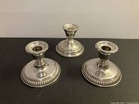 Front view of three sterling silver candle holders showing styles and sizes