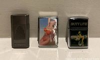 Front view of three closed flip-top lighters