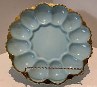 Top view of blue milk glass egg plate showing twelve wells and gold trim