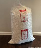 Full view of sealed Uline bag of packing peanuts standing upright