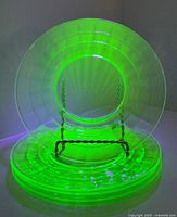 Five plates stacked with stand, glowing under UV