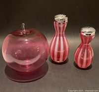 Front view of cranberry glass apple figurine and pair of shakers