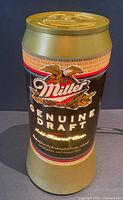 Front view of illuminated Miller Genuine Draft beer can lamp showing branding and light output