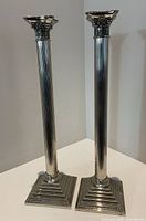 Full view of both candlesticks standing side by side showing height, column shafts and bases