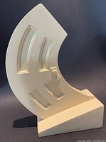 Front view of cream curved door sculpture on angled base