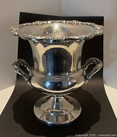 Front view of silver plate ice bucket on pedestal base with handles
