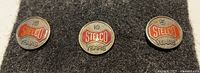 Front view of the three Stelco sterling service pins showing 5, 10, 15 year denominations and enamel detailing.