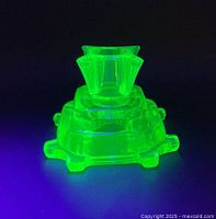 Candle holder glowing vivid green under UV light