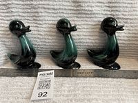 Front view of three BMP duck figurines with ruler for scale and lot tag