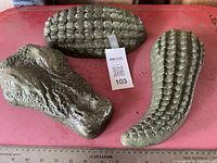 Three crocodile cement pieces on surface