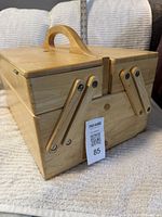 Closed wooden cantilever box front view with handle and articulated arms