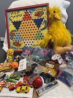 Group shot showing Chinese Checkers board, Big Bird plush, trading cards, Hot Wheels cars, My Little Pony figures in bag