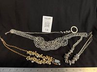 All four necklaces laid out with ruler for scale