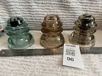 All three glass insulators beside ruler and lot tag