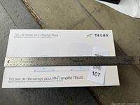 Front of sealed Telus Boost Wi-Fi Starter Pack box with scale ruler