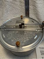 Top view of Whirley-Pop lid showing brand embossing and stirring mechanism