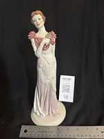 Full front view of porcelain figurine with ruler for scale