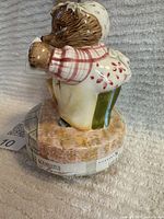 Side view of Mrs. Tiggy Winkle figurine on stone base showing labels