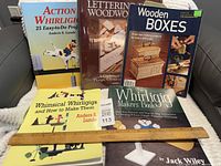 Front covers of five woodworking books displayed on sofa