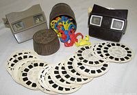 Front view of two View-Master viewers, barrel, monkey pieces and spread of reels