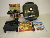 Group shot of cooktop, espresso maker, frying pan and three cookbooks