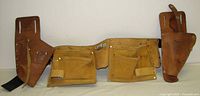 Front view of all three leather tool belts laid out showing pouches and belt sections