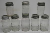 Front view of all eight jars showing embossing and lids